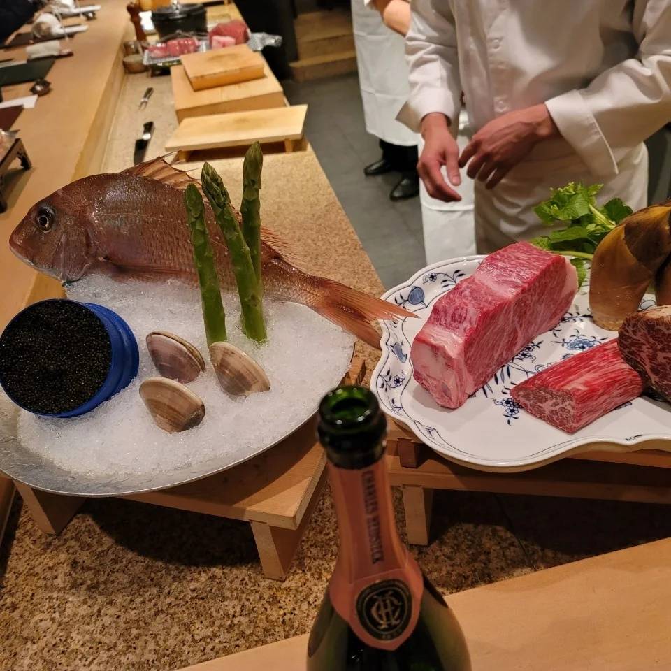 カウンターに並べられたハマグリと鯛と牛肉